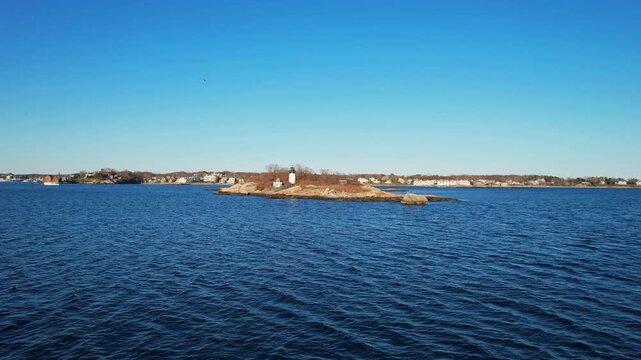 Drone approaching to a beautiful island with a lighthouse in Gloucester, impressive spring aerial view