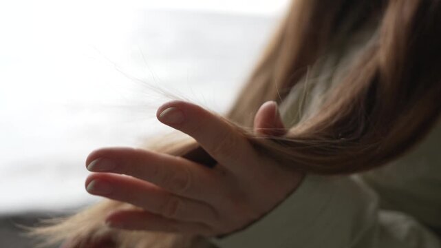 Haircare combing brunette a young woman combs her long brown hair while sitting by the sea for a natural wellness look