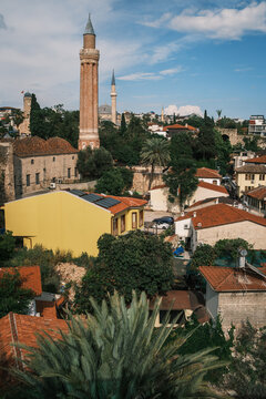 Scenic view of Yivli Minare Mosque fluted minaret rising above traditional red tiled roofs in Antalya old town Kaleici, historic seljuk landmark and urban cityscape, Turkey.