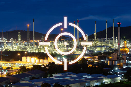 Industrial complex at night featuring refinery towers, power facilities. Targeting reticle overlay creates  concept symbolizing threats to critical energy infrastructure, geopolitical conflicts.