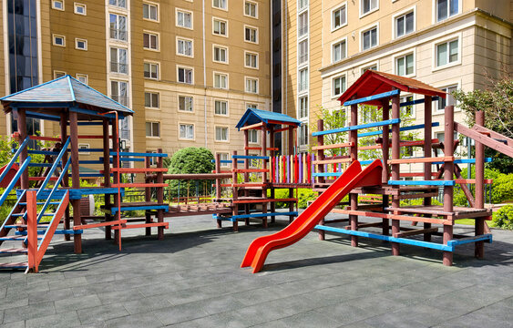 Playground area with slides and climbing structures in a residential neighborhood during daytime