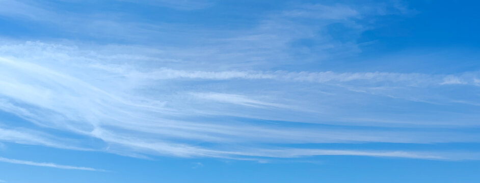 Panoramic light blue sky with thin white cirrus clouds texture background on beautiful summer day