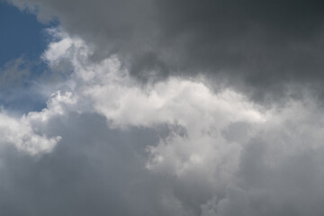 Obraz premium Luminous skies clash vividly. Vivid depiction of turbulent clouds against glowing daylight. Striking scene where storm clouds contrast sharply with luminous bright blue sky