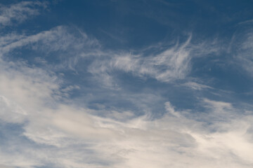 Obraz premium Skyward cloud patterns. Gentle wisps drift overhead. Delicate feather formations spread across bright sky. Graceful cirrus streaks paint serene and airy atmospheric scene