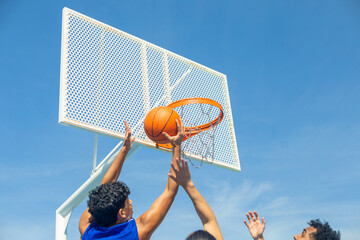 People playing basketball, scoring hoop outdoors © luisrojasstock