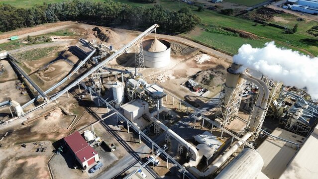 Industrial factory processing wood chips releasing smoke pollution