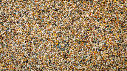 Fototapeta premium Various small stones and pebbles mixed together on the ground during daylight