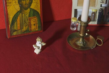 Obraz premium Various objects for prayer of the Christian faith Decorative statue with candle and icon on red tablecloth in a quiet room