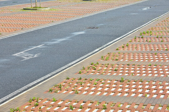 CONCRETE FLOORING BLOCKS IN A PUBLIC PARKING LOT permeable to rain water as required by the building laws used for sidewalks and parking areas - Permeable interlocking concrete pavers - PICP