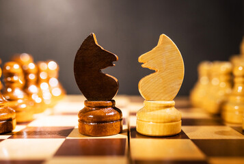 chess pieces of knights on a chessboard on a dark background © ketrin