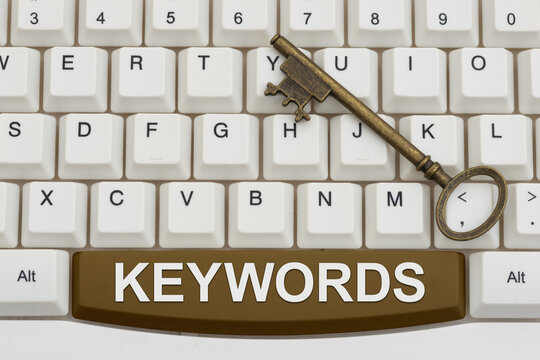 Keywords text with a vintage key on white computer keyboard for keyword research