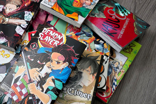 Close up of a stack of Shonen Jump manga including Demon Slayer and Kaiju No 8 laying on a gray wood floor, May 28, 2026, Schaumburg IL