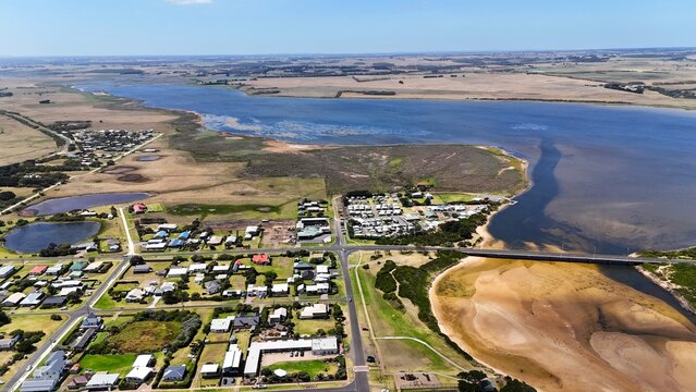 Aerial panorama of the coastal town of Peterborough, the Curdies River estuary, and farmlands on the Great Ocean Road, Victoria, Australia.
