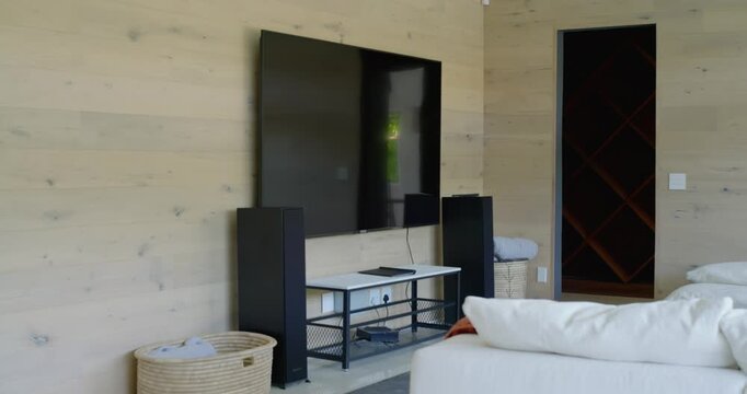 Camera is panning right in lounge, revealing sofa, TV, console, window, and showing natural light