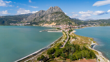 Fototapeta premium drone panorama of the inhabited Lake Egirdir peninsula showing coastal houses and small harbors. Scenic lakeside town architecture and mountain peak landscape in Anatolia, Turkey.