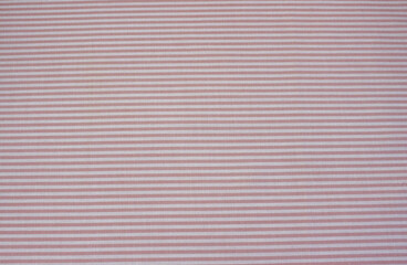 Fototapeta premium Texture of pink and white horizontal striped cotton cloth background. Close up of classic pink striped fabric. 