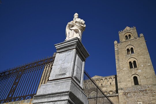 Landscape with scenic view of a marble sculped religious statue on the exterior of the Norman-Arab-Byzantine style Duomo di Cefal&ugrave; in Sicily Italy.