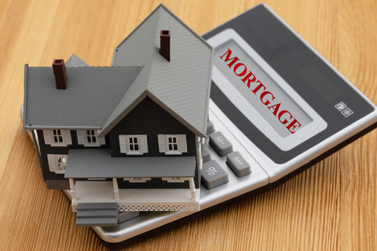 Mortgage text on a house on a calculator on a desk for house payments