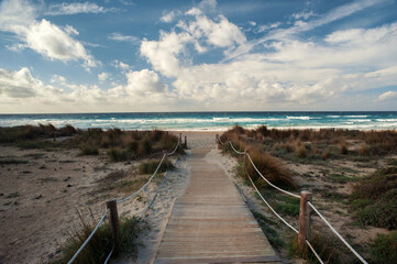 Fototapeta premium Wooden Boardwalk Leading To Sandy Beach And Turquoise Sea – Tropical Coastal Summer Landscape