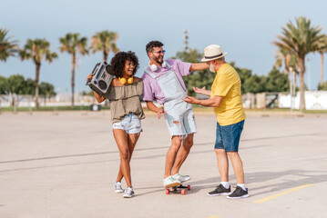Obraz premium Multigenerational family having fun outdoors with music and skateboard