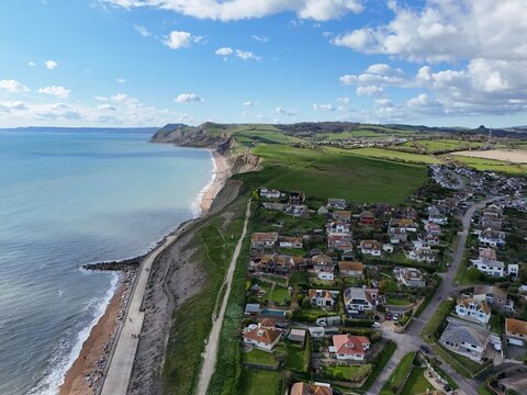 Houses on cliff edge West Bay Dorset UK pull back drone aerial view