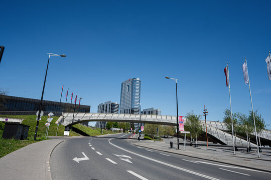 Modern urban road and pedestrian bridge with highrise skyline in Katowice, Poland, contemporary architecture under a clear blue sky