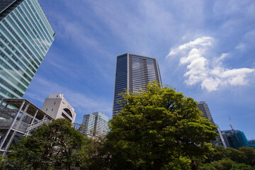 Obraz premium Lush green lawn of Kyu-Shiba-rikyu Gardens and skyscrapers symbolizing an urban oasis September 2023