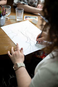 Women practicing neurographic drawing during a creative self-development workshop. Mindfulness, art therapy, learning and personal growth concept.
