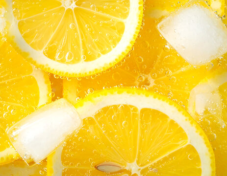Fresh lemon slices falling into sparkling water with bubbles and splashes. Bright yellow citrus macro photo, perfect for beverage, freshness, summer, cocktail and healthy lifestyle visuals