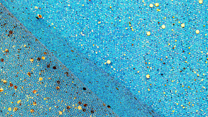 Colorful fabric with texture and pattern in blue tones scattered with shiny elements in a bright light setting © Fleuronica