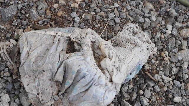 Used diapers discarded on the ground are dirty and constitute waste, posing a health hazard and attracting pests.