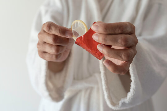 Woman holding a condom in her hands. The concept of safe sex.