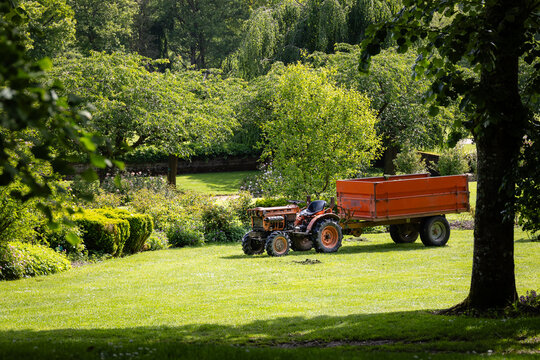 Tracteur avec remorque, entretien du parc par le jardinier, espaces verts