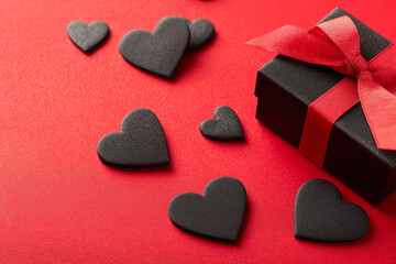 Fototapeta premium valentine's day white background with red hearts, gift box, and ribbon on a bright red tabletop. love concept for holiday celebration, greeting card, or poster template. flat lay style. stock photo, h