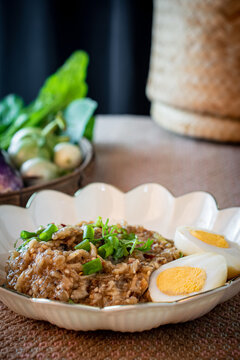 Healthy Thai pounded eggplant salad with boiled egg and herbs. Known as Tam Ma Khua in Northern Thailand or Soup Ma Khua in Isan, representing authentic regional Asian rustic home-cooked dining