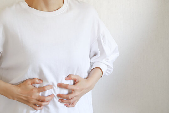 胃の痛みを感じる女性