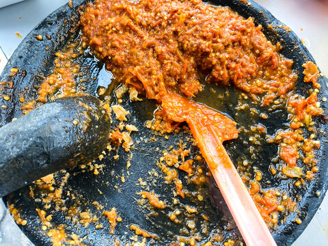 Top view of authentic Indonesian sambal oelek made from chilies in a stone mortar