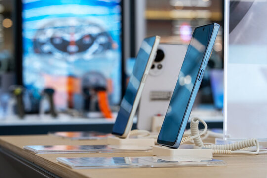 Smartphones is sold at mobile phones store. Showcase with smartphones in the modern electronics store. Buy a mobile phone. Selective focus.