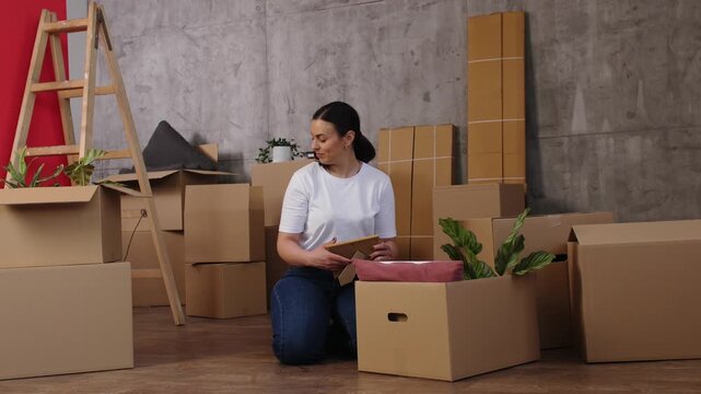 Woman unpacking personal belongings after moving house