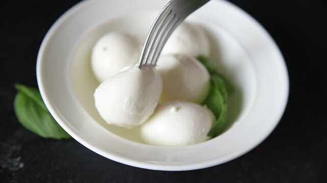 Mini mozzarella or mini burrata soft, young cheese lunch or dinner tasty snack organic fresh and gourmet food background on the table rustic food top view copy space