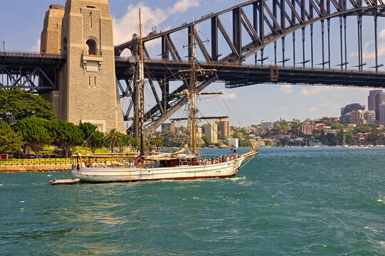 Sailing ship passing by Sydney Harbour Bridge, Australia