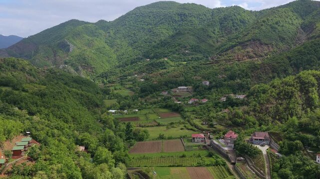 Beautiful landscape aerial video of Katund i Vjeter village in Albania, showing green hills, agricultural fields, and rural houses.