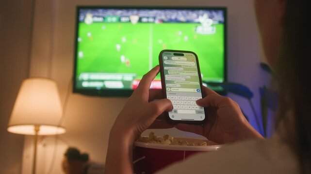 Woman football fan watching a match at home and texting her friend GOAL in a messenger during an exciting moment of the game. Sports emotions and live football reaction concept. High quality 4k
