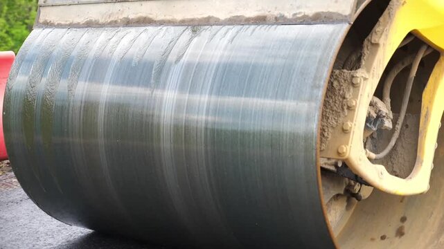Compactor constructing highway. Steamroller slowly ride. Roadway repair by heavy machinery. Roller laying new asphalt layer. Special machinery making road. Concept of roadwork and motorway maintenance