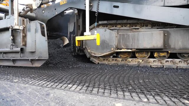 Slowly driving roller laying new asphalt layer. Special machinery making road in countryside area. Compactor constructing highway. Heavy machinery repairing road. Roadwork process. Roadway repair