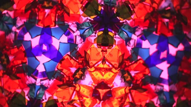 Description: Video of a natural kaleidoscope smoothly rotating. Vibrant red, blue, pink, and orange patterns ideal for VJ loops, concert visuals, ambient backdrops, website backgrounds, or creative vi