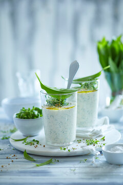 Creamy wild garlic quark topped with fresh cress and olive oil &ndash; a light and herbaceous spring dip captured in soft natural daylight.