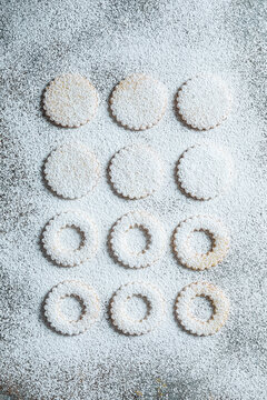 Top view of Linzer cookies with red jam and powdered sugar on a rustic surface