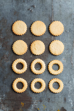 Top view of Linzer cookies with red jam and powdered sugar on a rustic surface