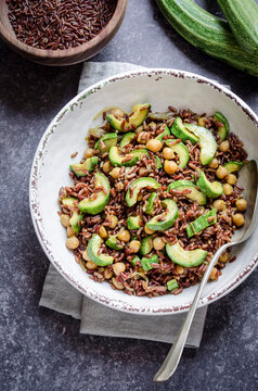 Red rice salad with chickpeas and zucchini in a bowl